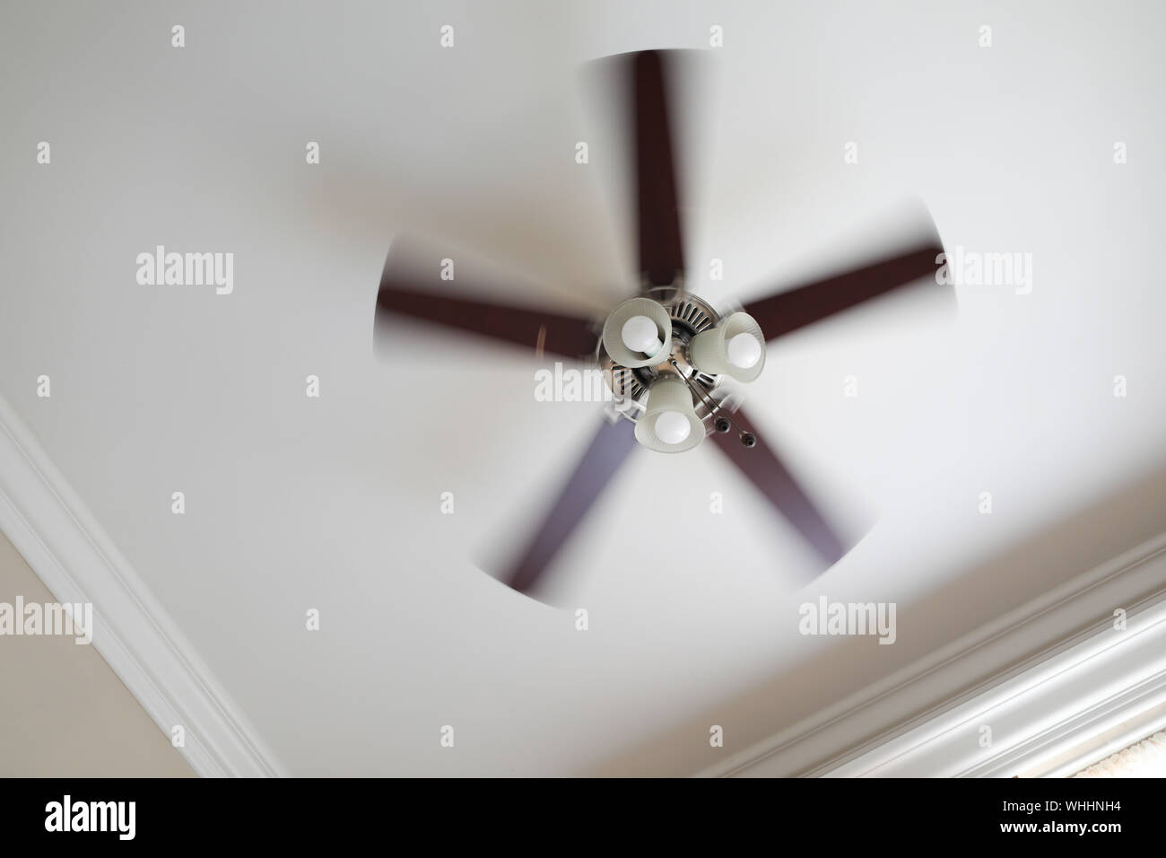 A Working Ceiling Fan On A White Ceiling Close Up With Blurred