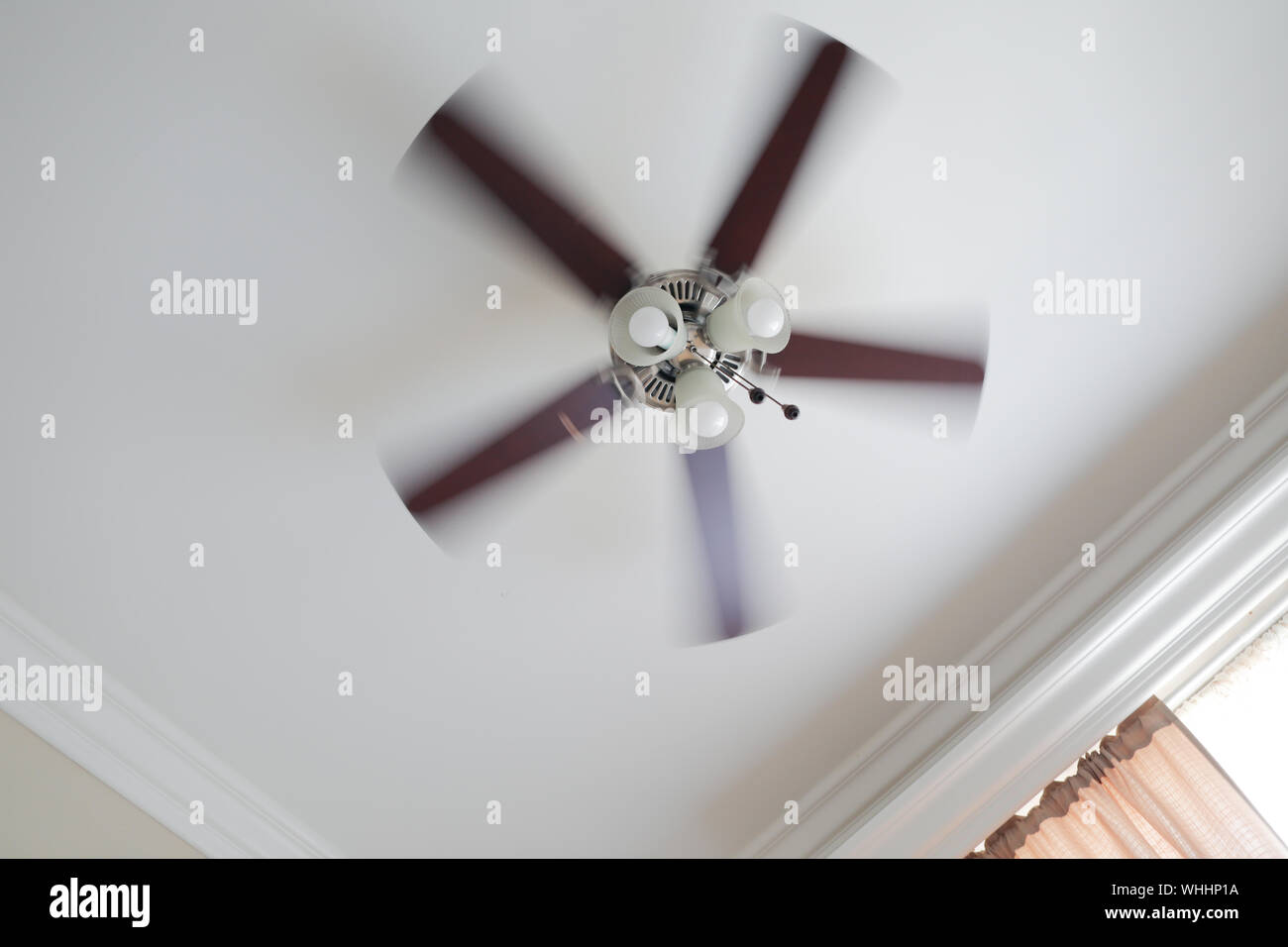 Ceiling Fan With A Ceiling Lamp Turned On Working With Blurred