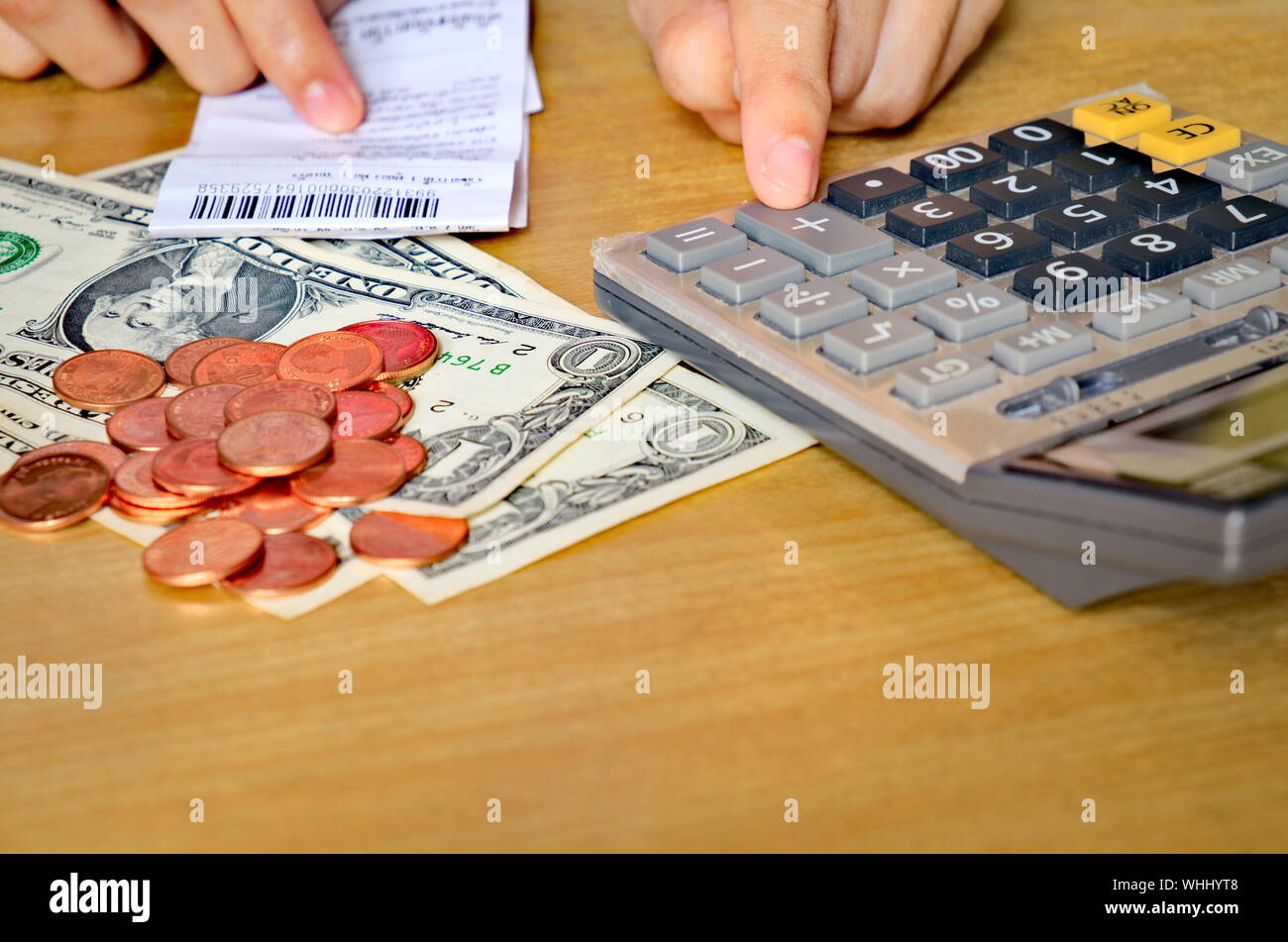 Close-up Of Hands Touching Calculator And Financial Bill On Table Stock Photo