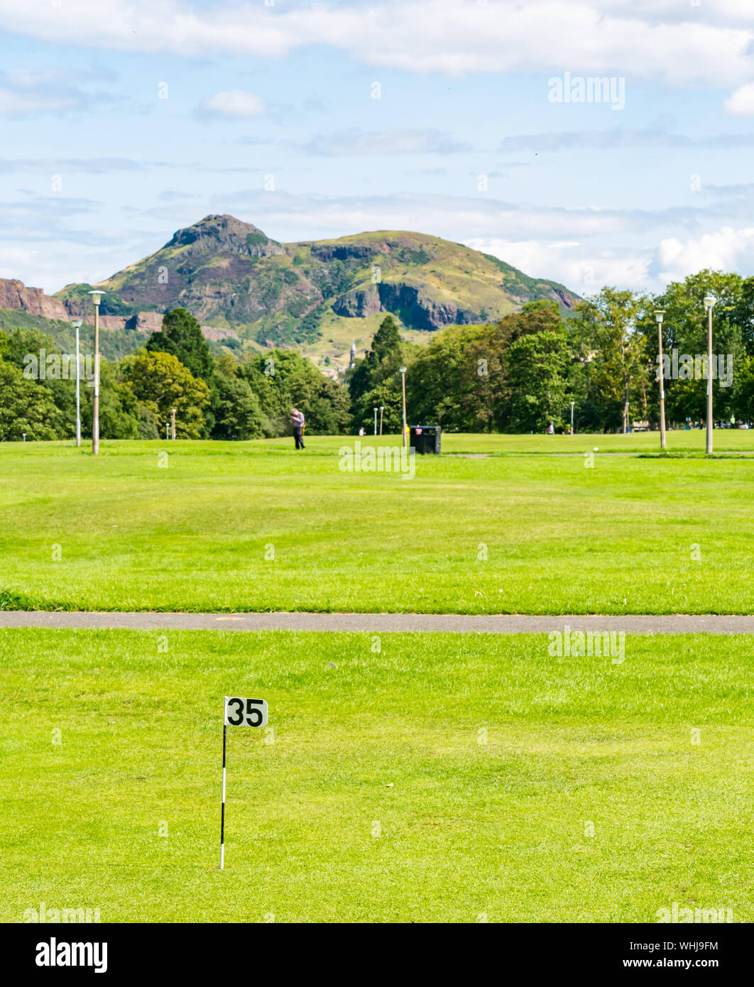Putting green golf hole number 35, The Meadows, Edinburgh, Scotland, UK, with view of Arthur's Seat Stock Photo