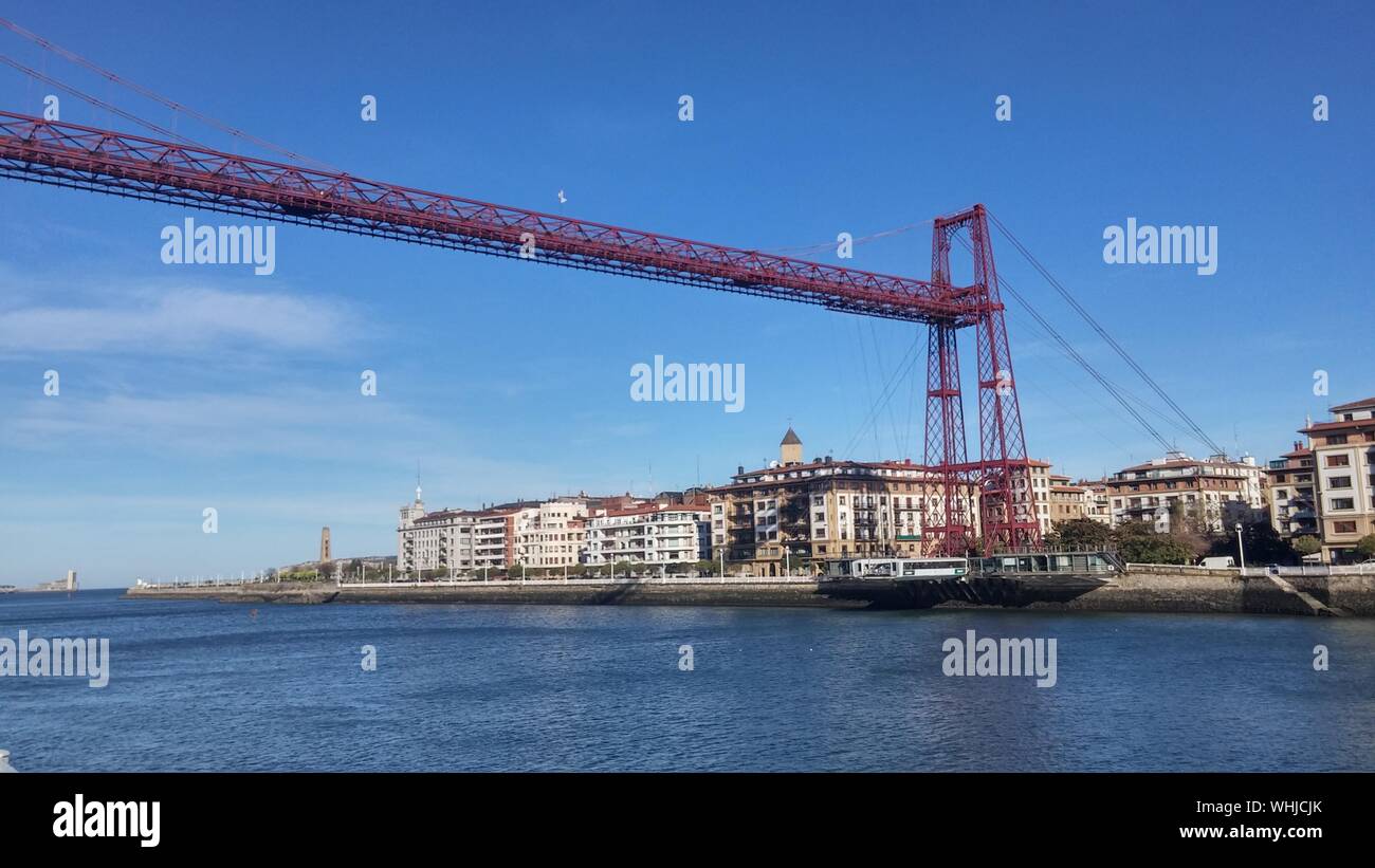 Vizcaya Bridge Over River By Buildings Against Sky Stock Photo