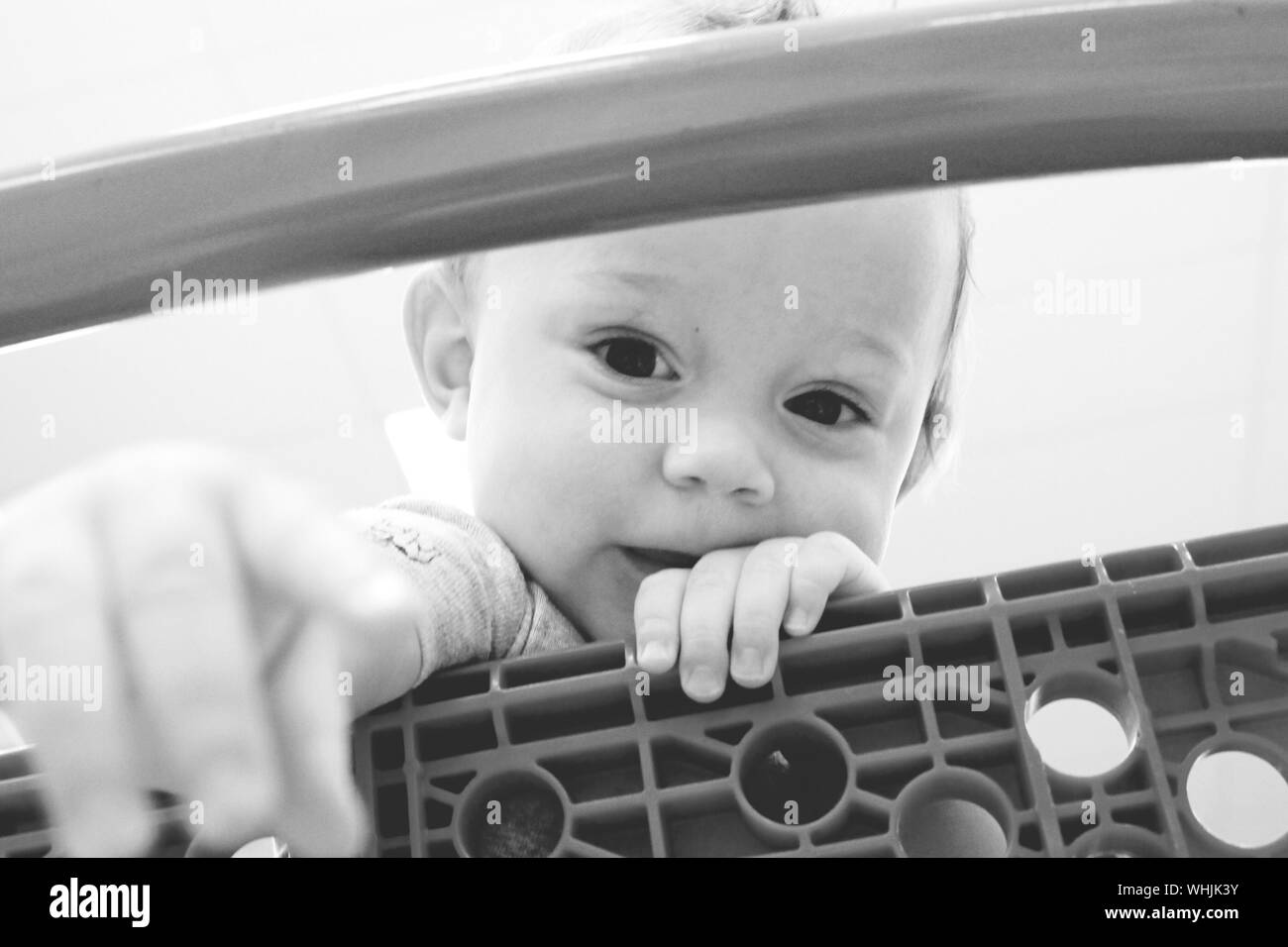Portrait Of Cute Baby Seen Through Shopping Cart At Super Market Stock Photo