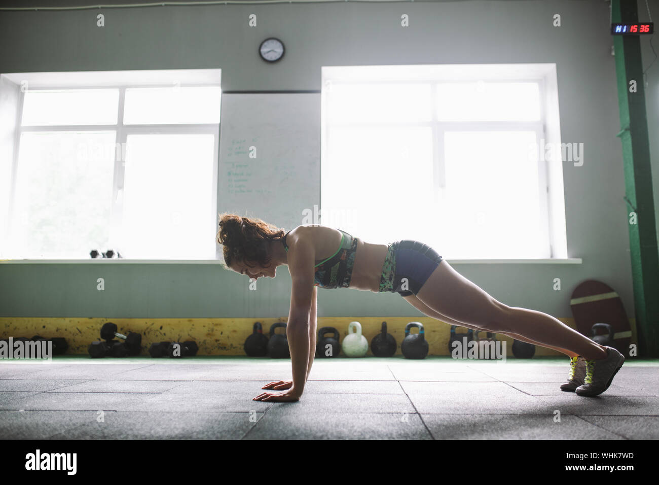 A beautiful girl does pushups from the floor for training the muscles