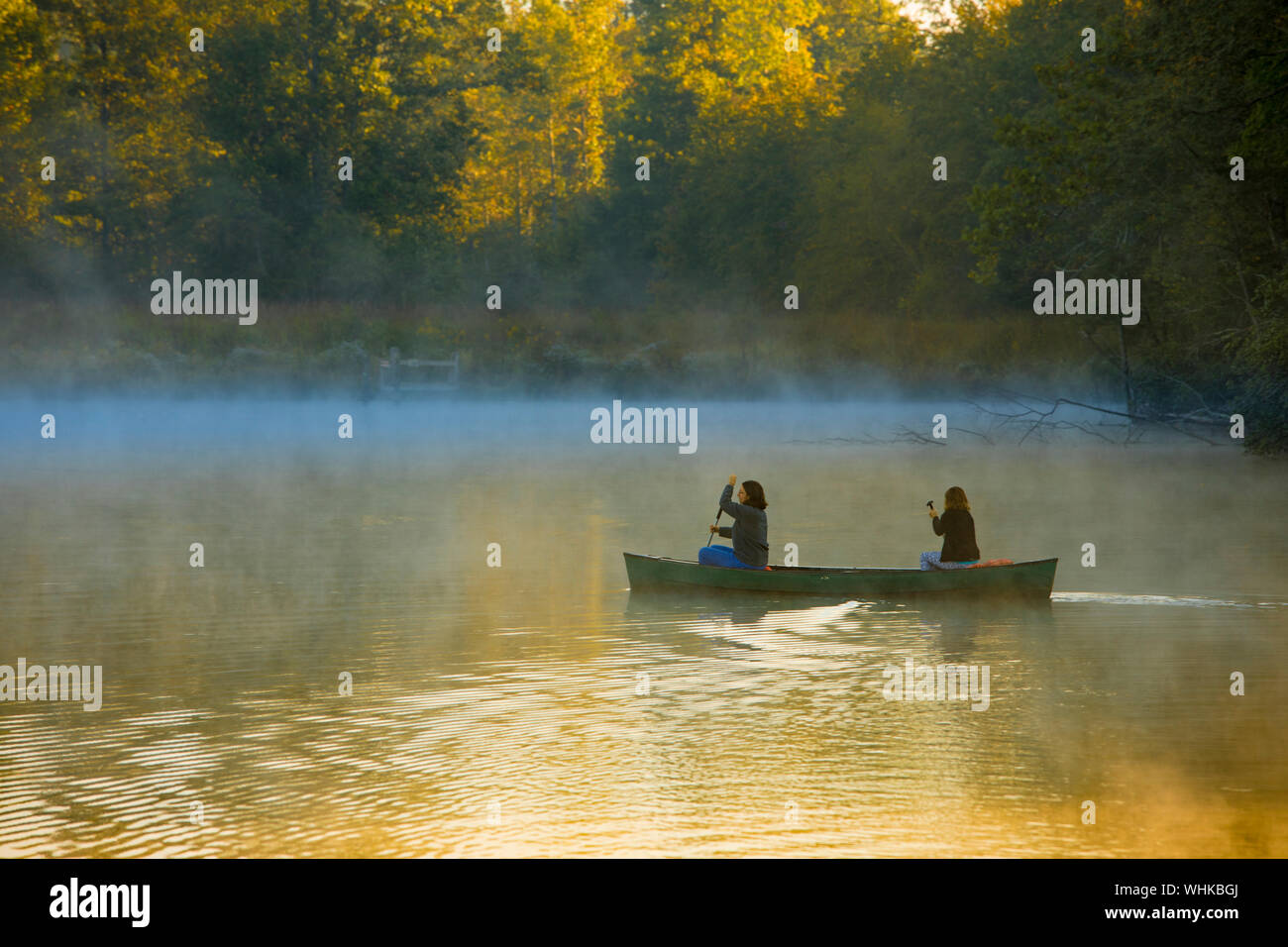 Mother and daughter canoeing through morning mist near Saluda, North Carolina Stock Photo