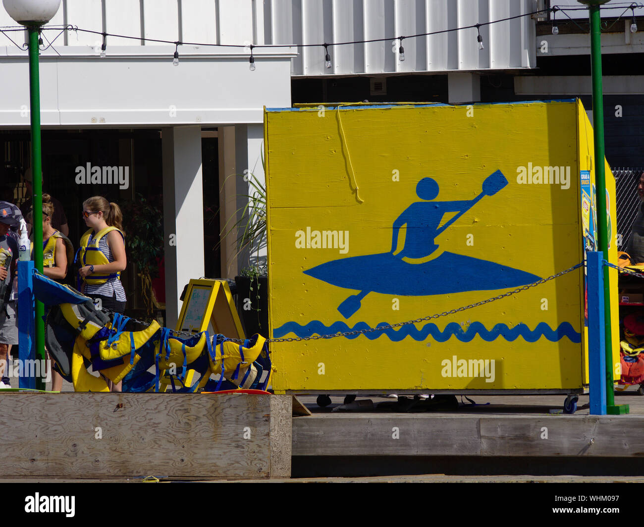 People in yellow life jackets waiting for their boats at the boat rental kiosk, Dow's Lake