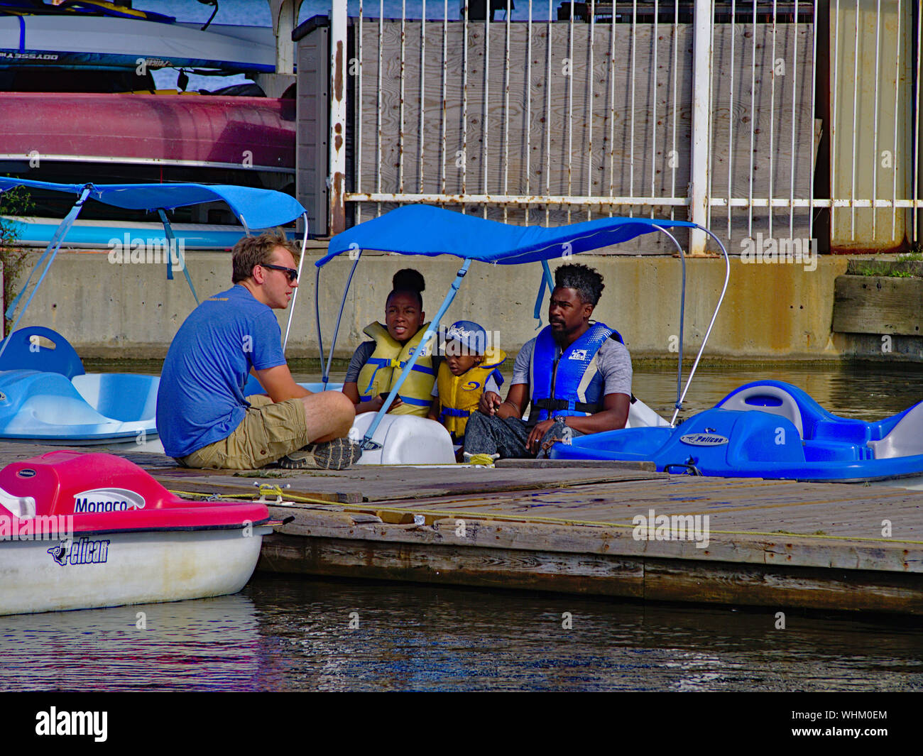 Boat rental crew launching a family in a pedalo from the dock at Dow's