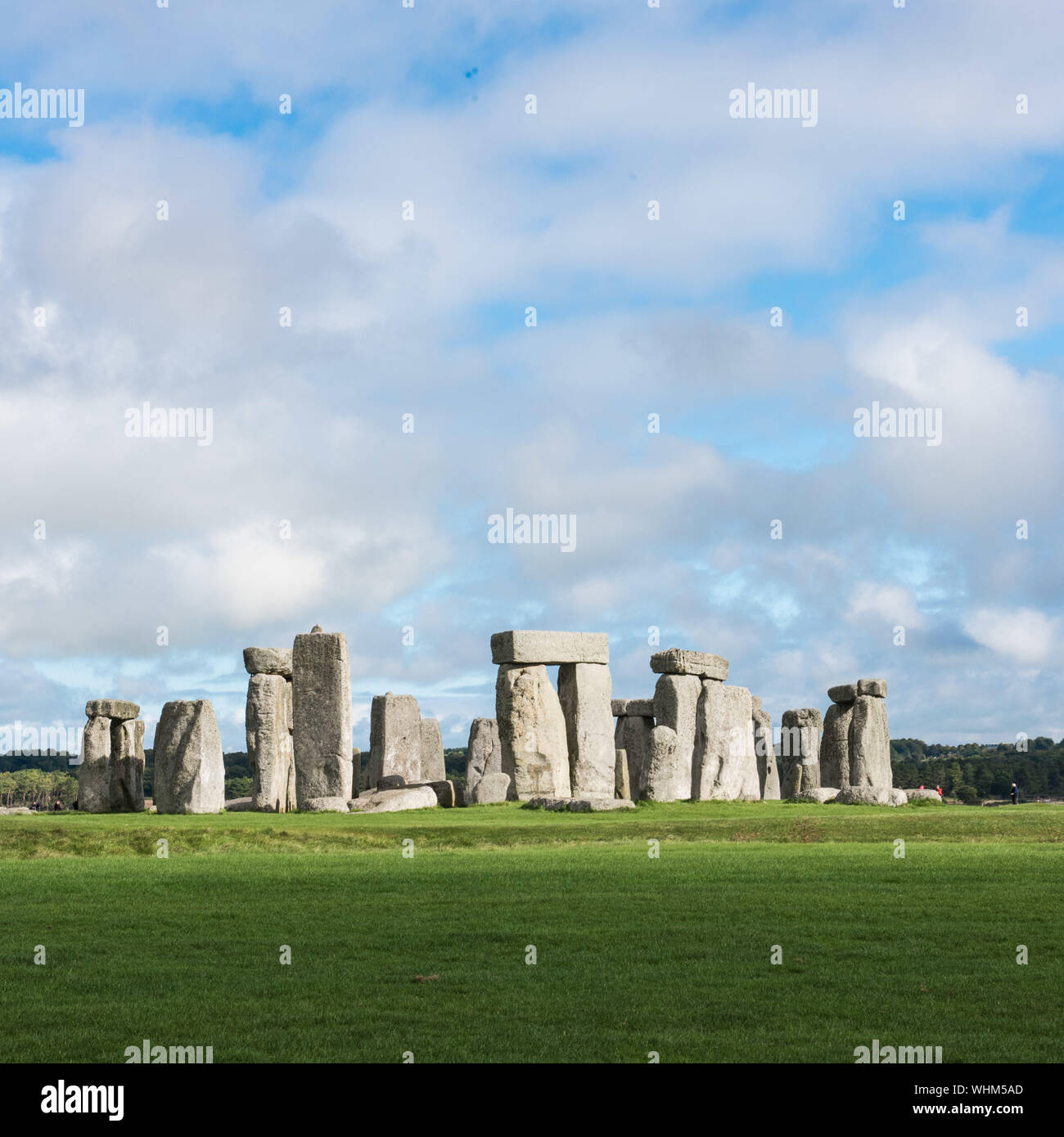 Megalith Rocks On Grassy Field Against Cloudy Sky Stock Photo
