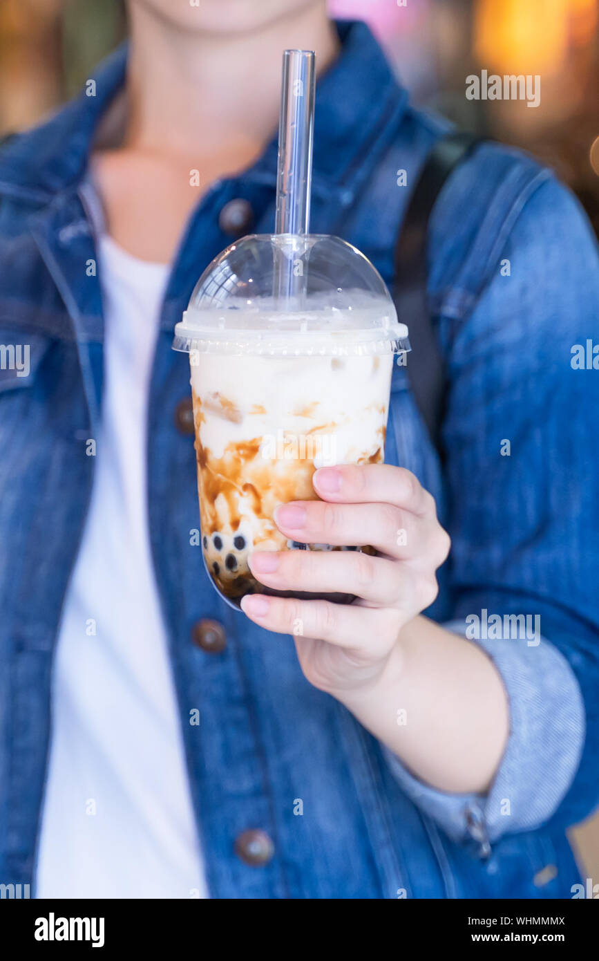 Young Girl In Denim Jacket Is Drinking Brown Sugar Flavored Tapioca Pearl Bubble Milk Tea With Glass Straw In Night Market Of Taiwan Close Up Bokeh Stock Photo Alamy