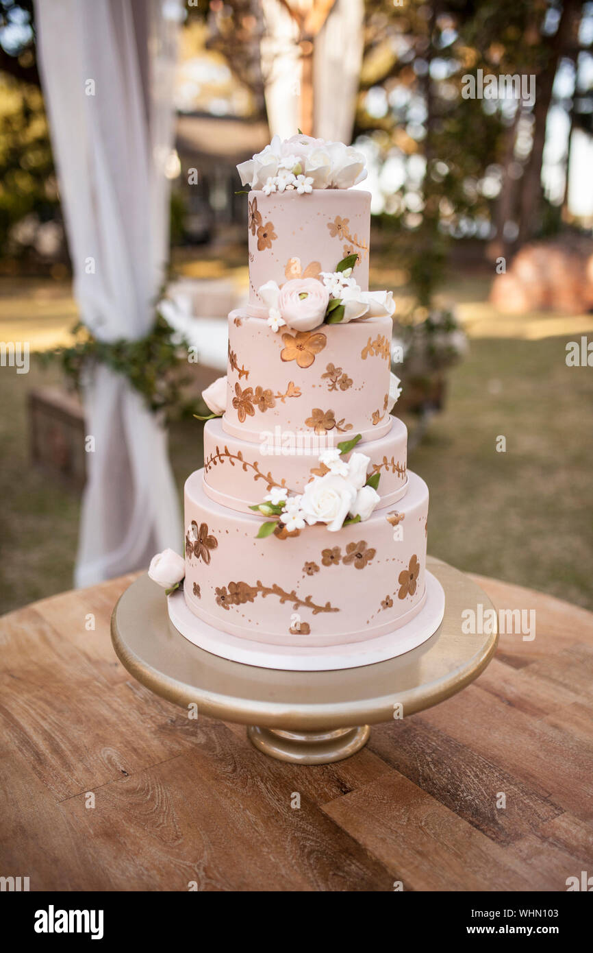 Four Tiered Wedding Cake With White Roses At Outdoor Reception