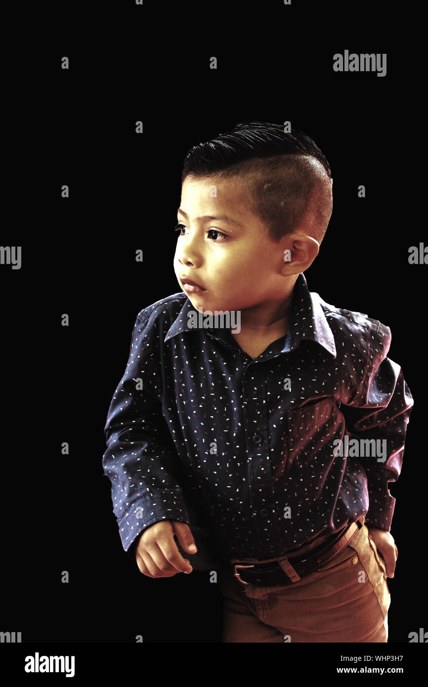 Boy In Smart Casual Standing Against Black Background Stock Photo