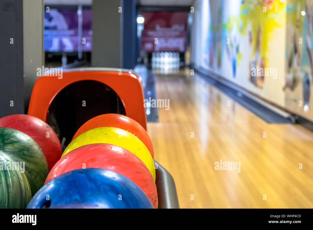 Bowling balls in a row waiting to be thrown at bowling club Stock Photo