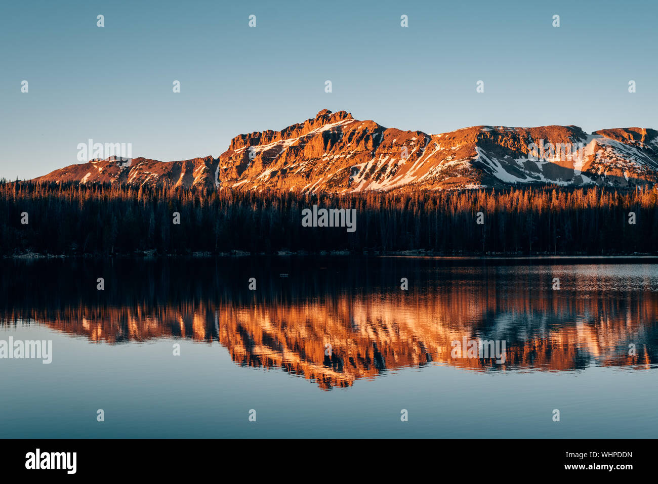 Snowy mountains reflecting in Mirror Lake, in the Uinta Mountains, Utah Stock Photo