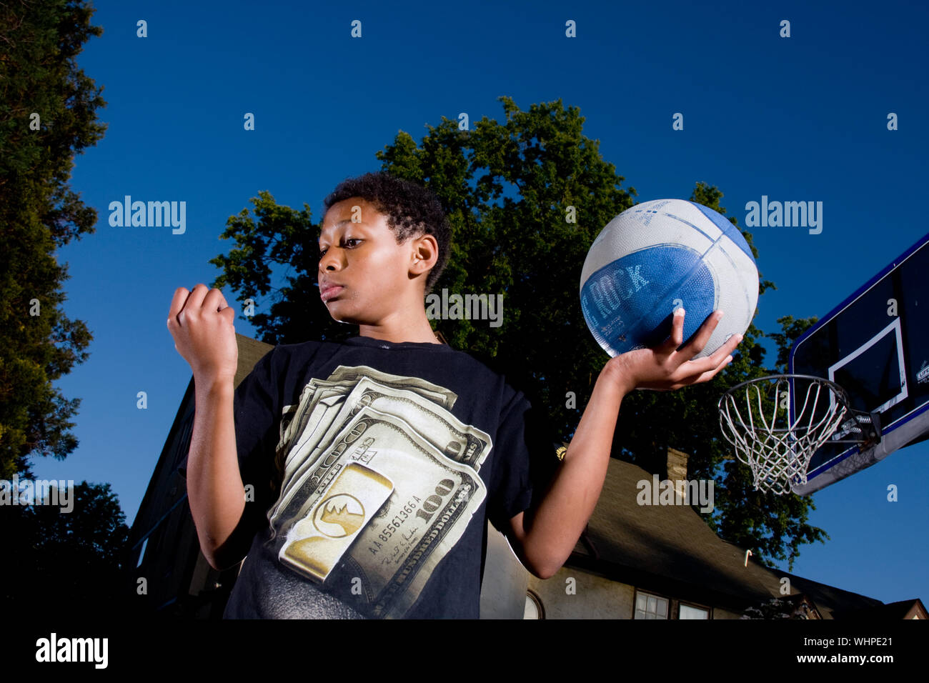 Eleven year old African American boy plays basketball at his suburban home outside Philadelphia PA Stock Photo