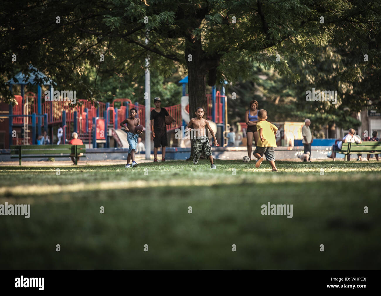 minority children play sports and games in a public park in Kensington , northern Philadelphia PA Stock Photo