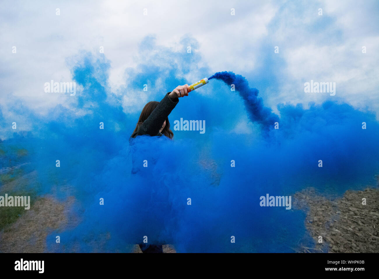 Woman Standing Amidst Distress Flare Stock Photo
