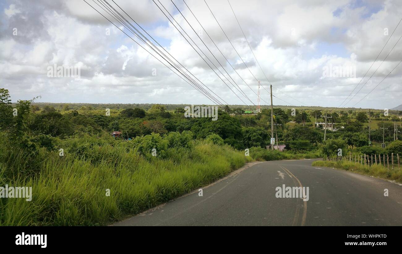 Road Passing Through Field Against Cloudy Sky Stock Photo - Alamy