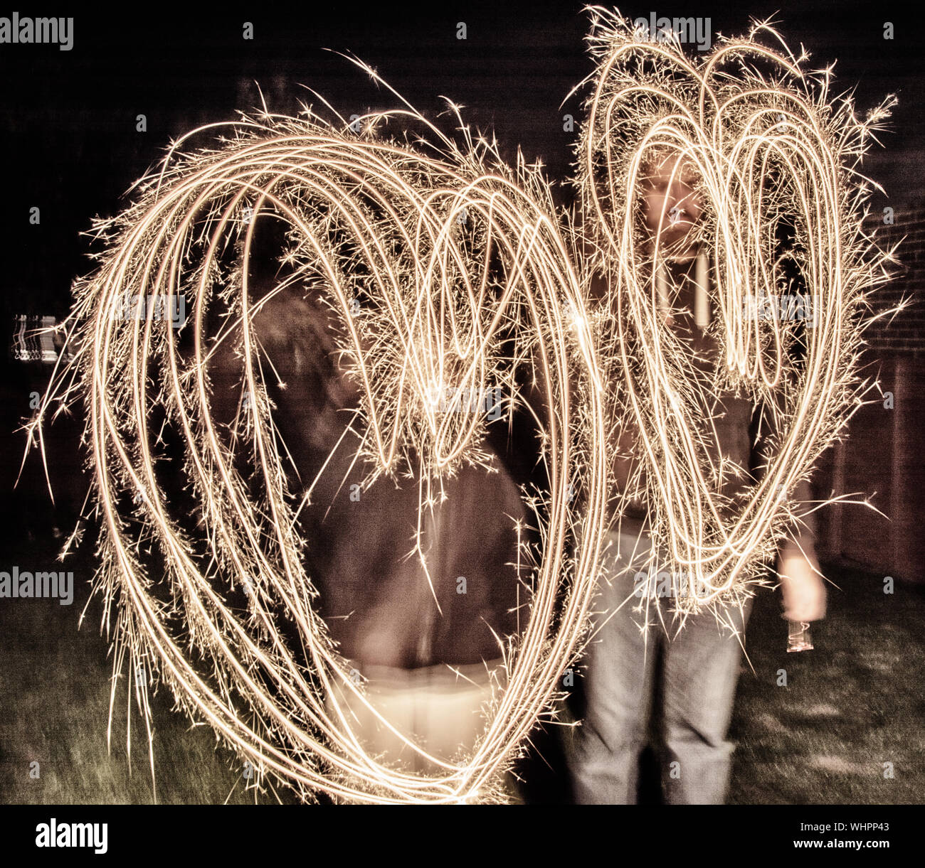 Men Making Heart Shape With Sparklers At Night Stock Photo