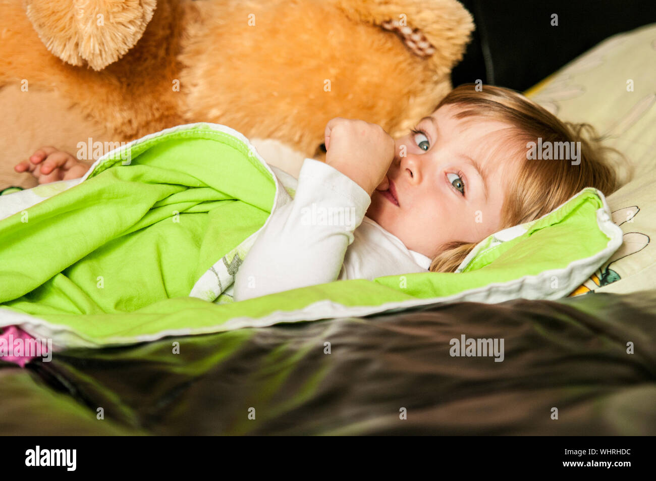 Young Child Lying In Bed Stock Photo