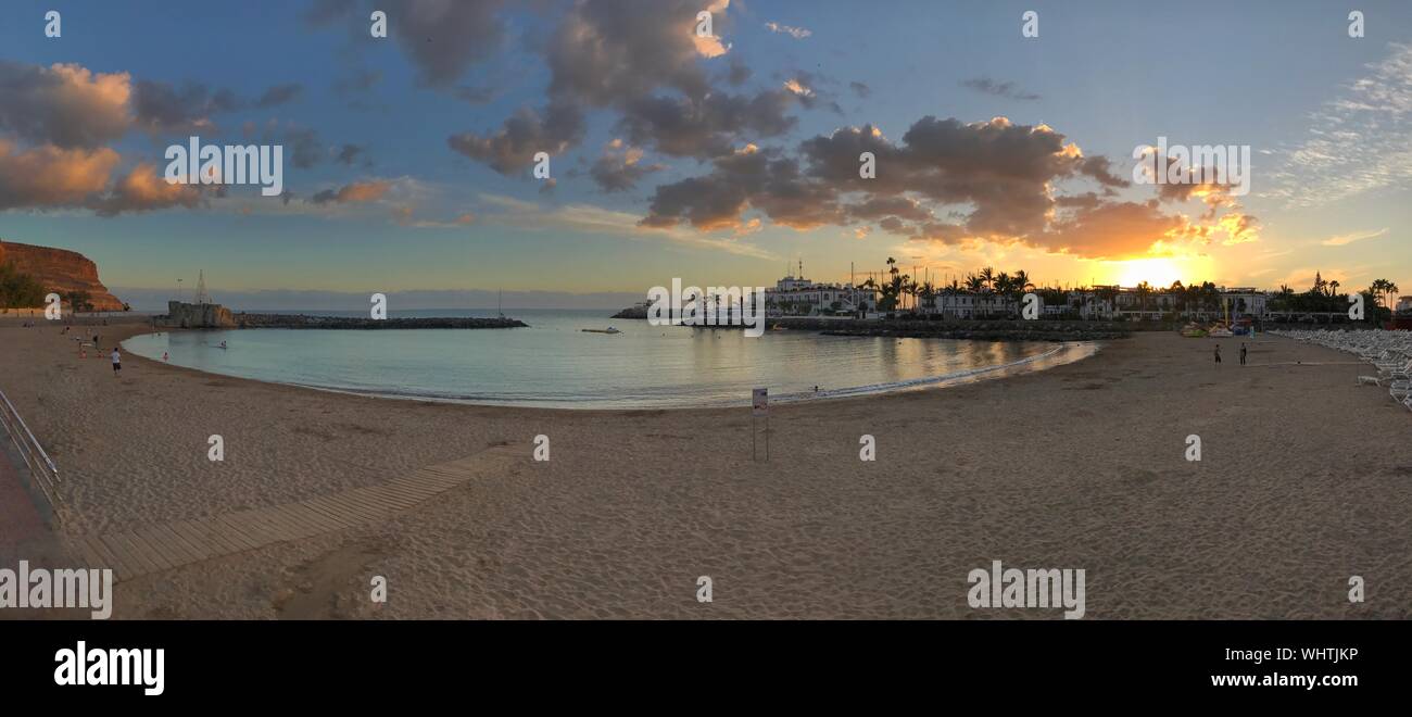 Panoramic View Of Grand Canary Beach Against Cloudy Sky During Sunset Stock Photo