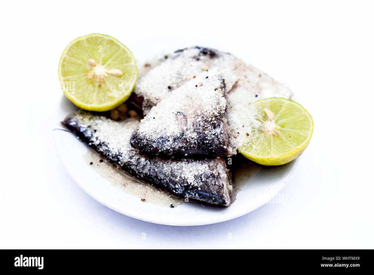 Marinated fish with lime or lemon juice in a glass plate isolated on