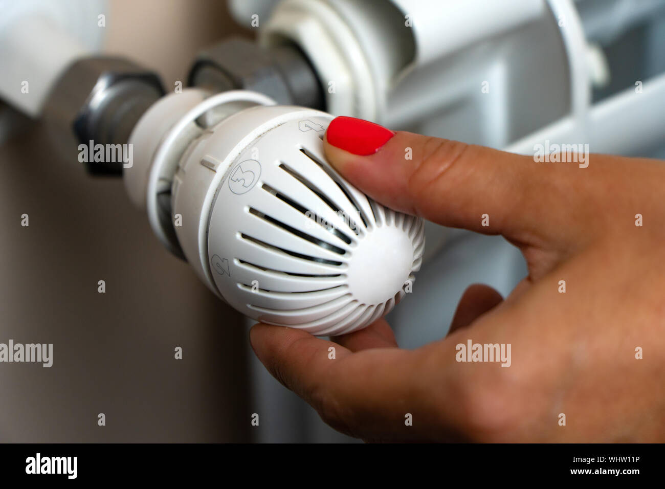 Woman Hand Adjusting The Temperature By Thermostat Stock Photo - Alamy