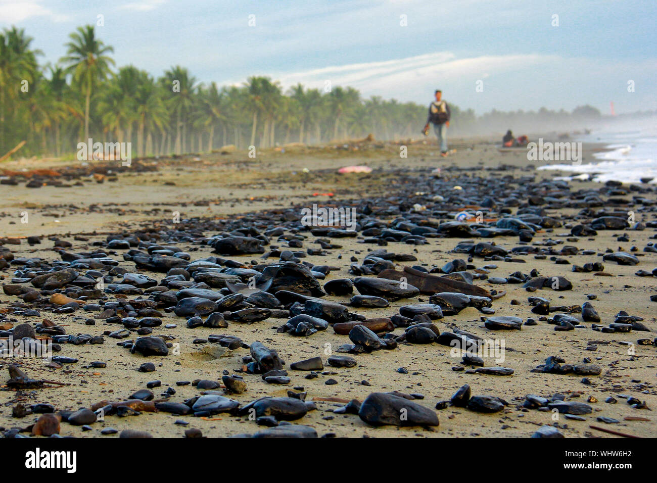 Meulaboh, Indonesia. 01st Sep, 2019. Visitors walk at the coastal area polluted by waste coal in Peunaga Rayeuk.The existence of waste coal is suspected to belong to one company that operates around the beach. Consequently, some fishermen suffered losses due to diminished catches and lack of coastal visitors in the area. Credit: SOPA Images Limited/Alamy Live News Stock Photo