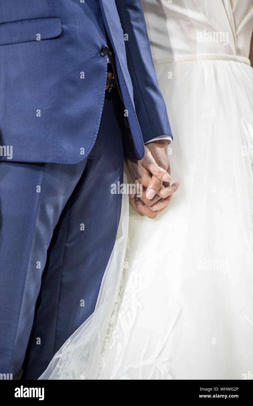 Midsection Of Couple Holding Hands During Wedding Ceremony Stock Photo