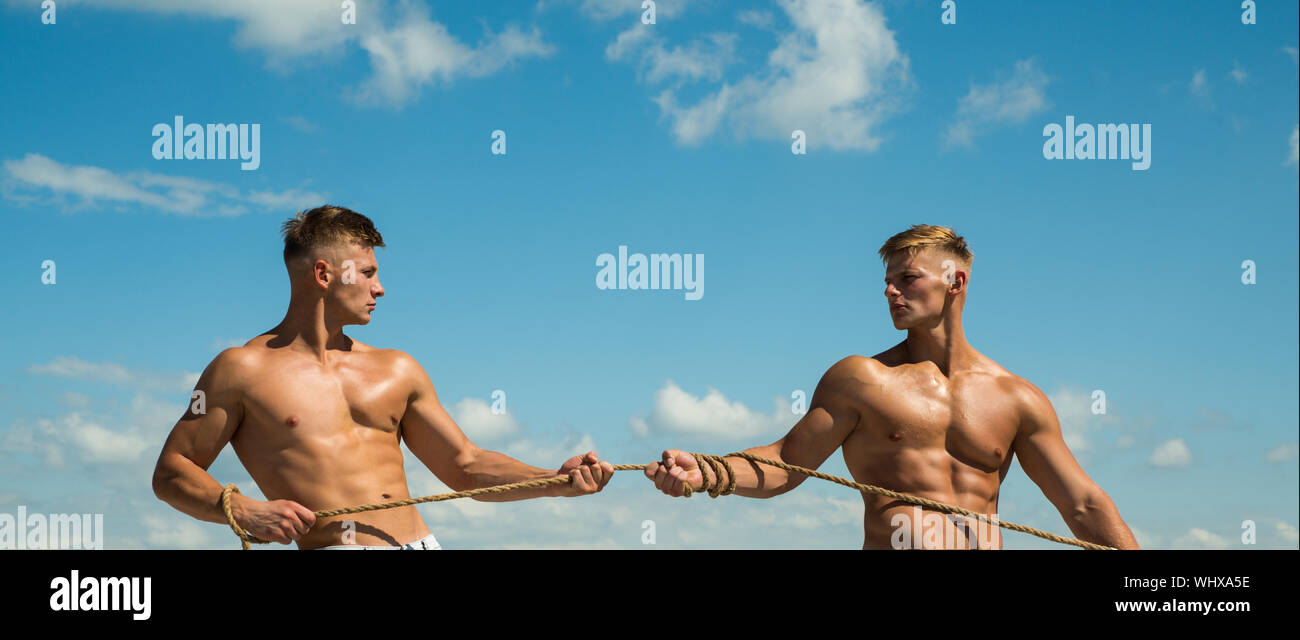 Fit and full of strength. Strong men pull rope with muscular hand ...