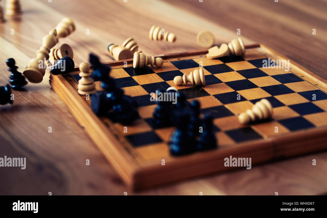 Wooden chess pieces are lying on a chessboard. Concept logic, strategy, defeat Stock Photo