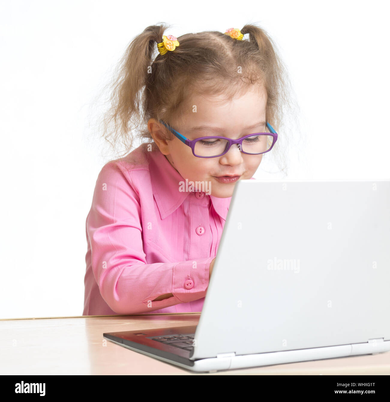 Happy kid in spectacles using notebook with great interest isolated on white Stock Photo