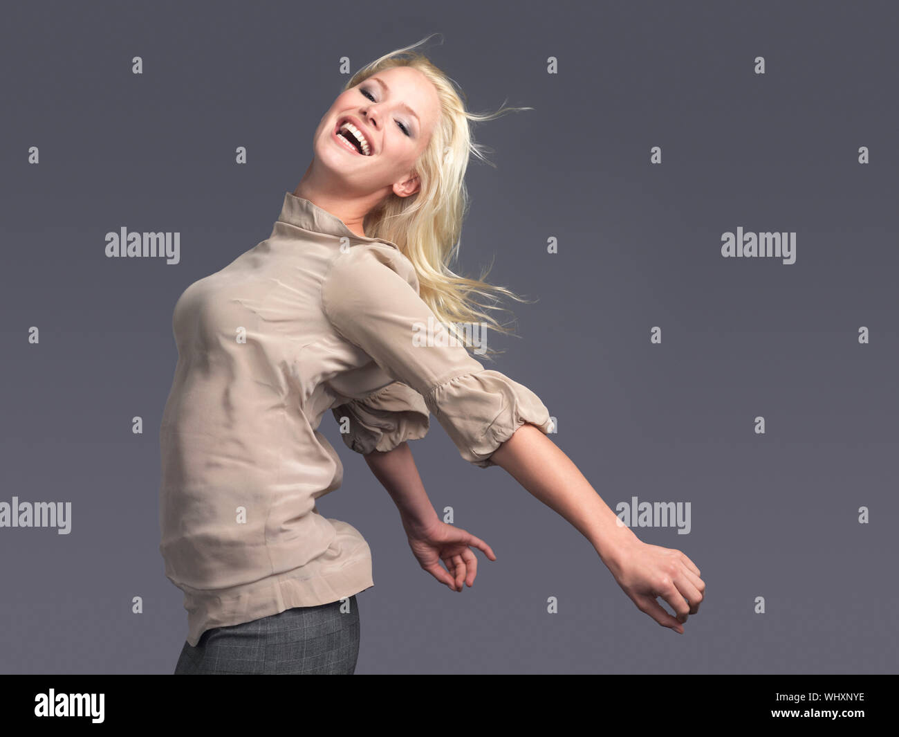 Side View Of A Happy Young Blond Woman Standing With Arms Outstretched Against Gray Background Stock Photo Alamy Side View Of A Happy Young Blond Woman Standing With Arms Outstretched Against Gray Background Stock Photo Alamy