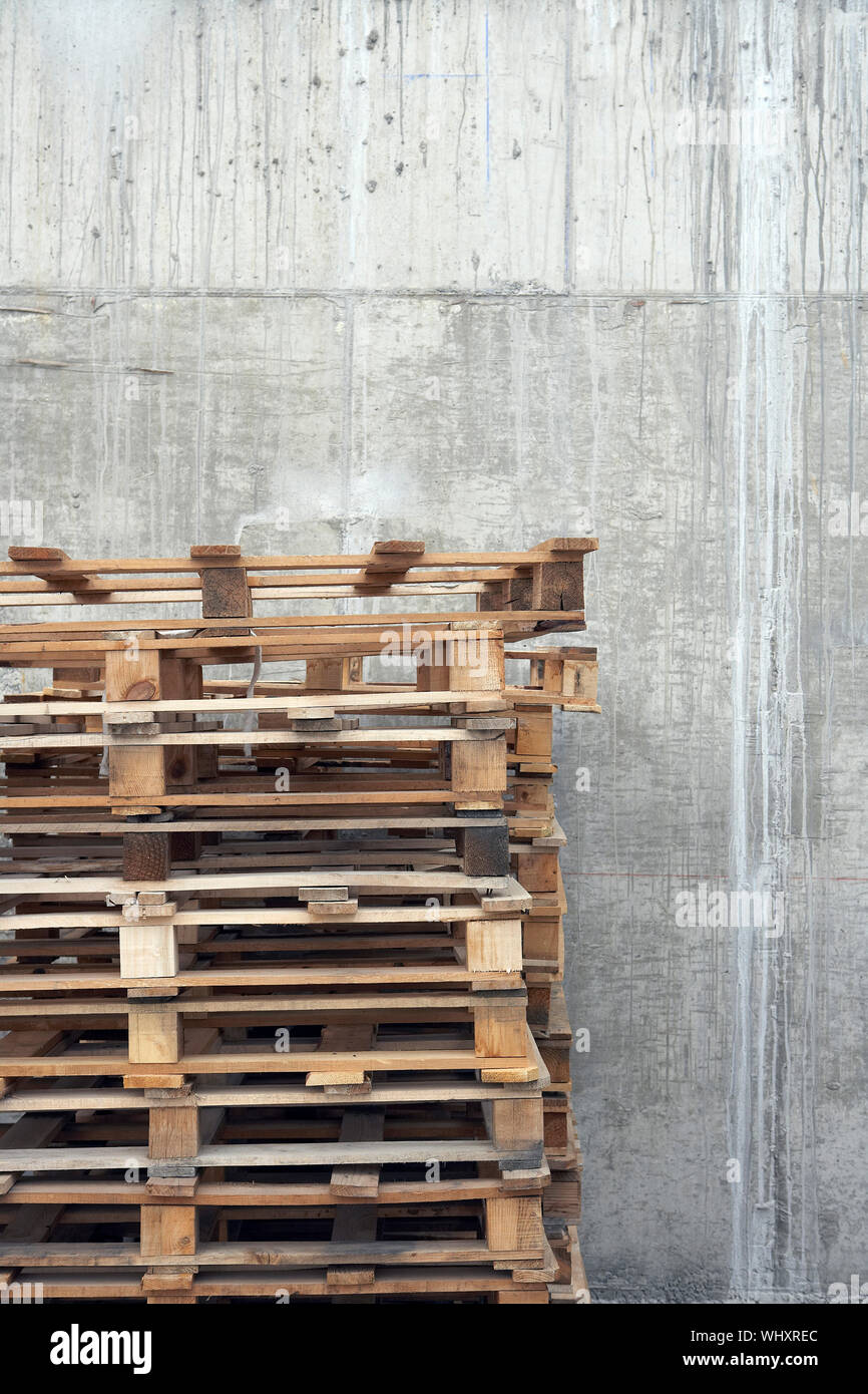Closeup Of A Stack Of Wooden Pallets Against Concrete Wall Stock