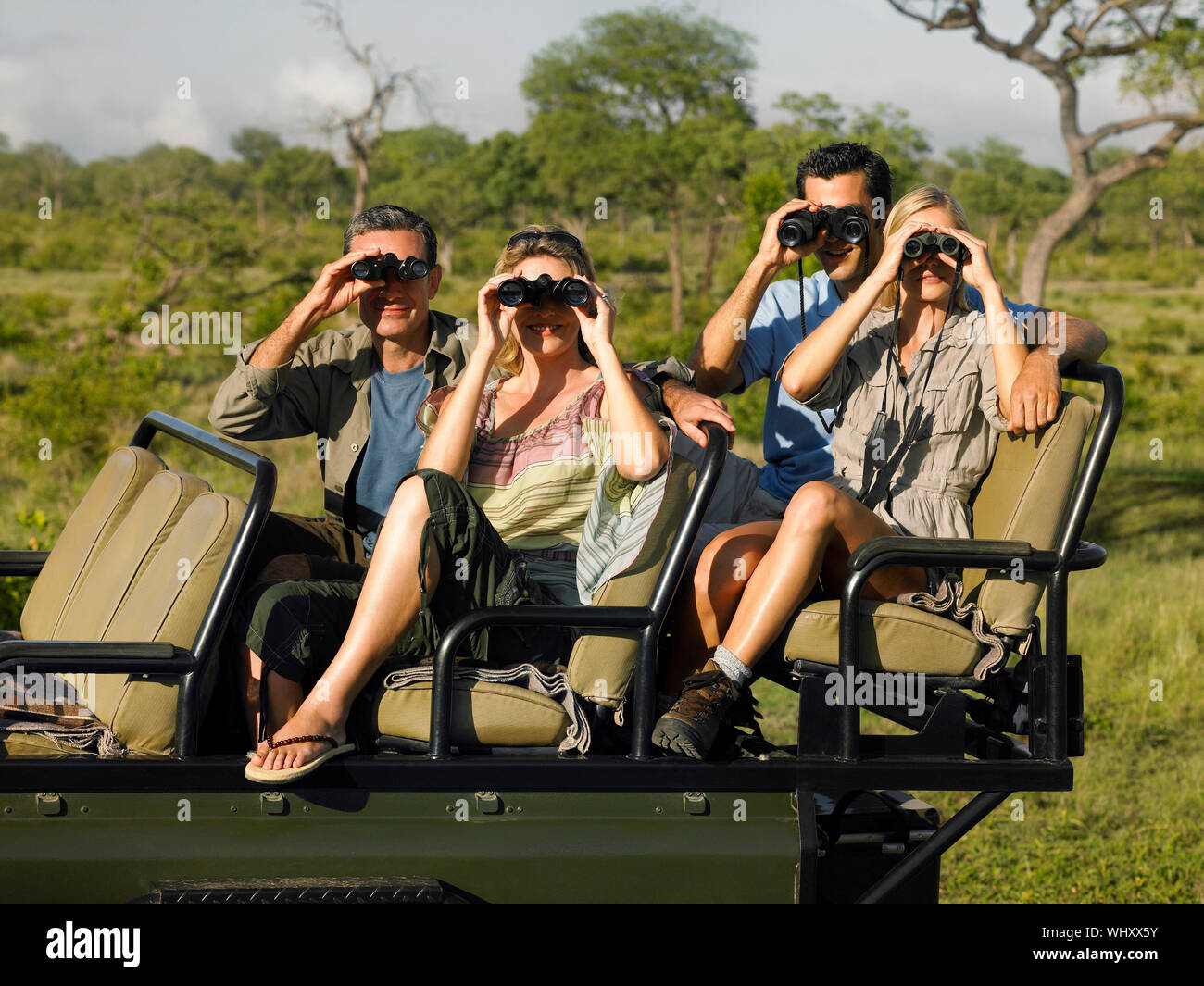 Group of tourists sitting in jeep and looking through binoculars Stock  Photo - Alamy