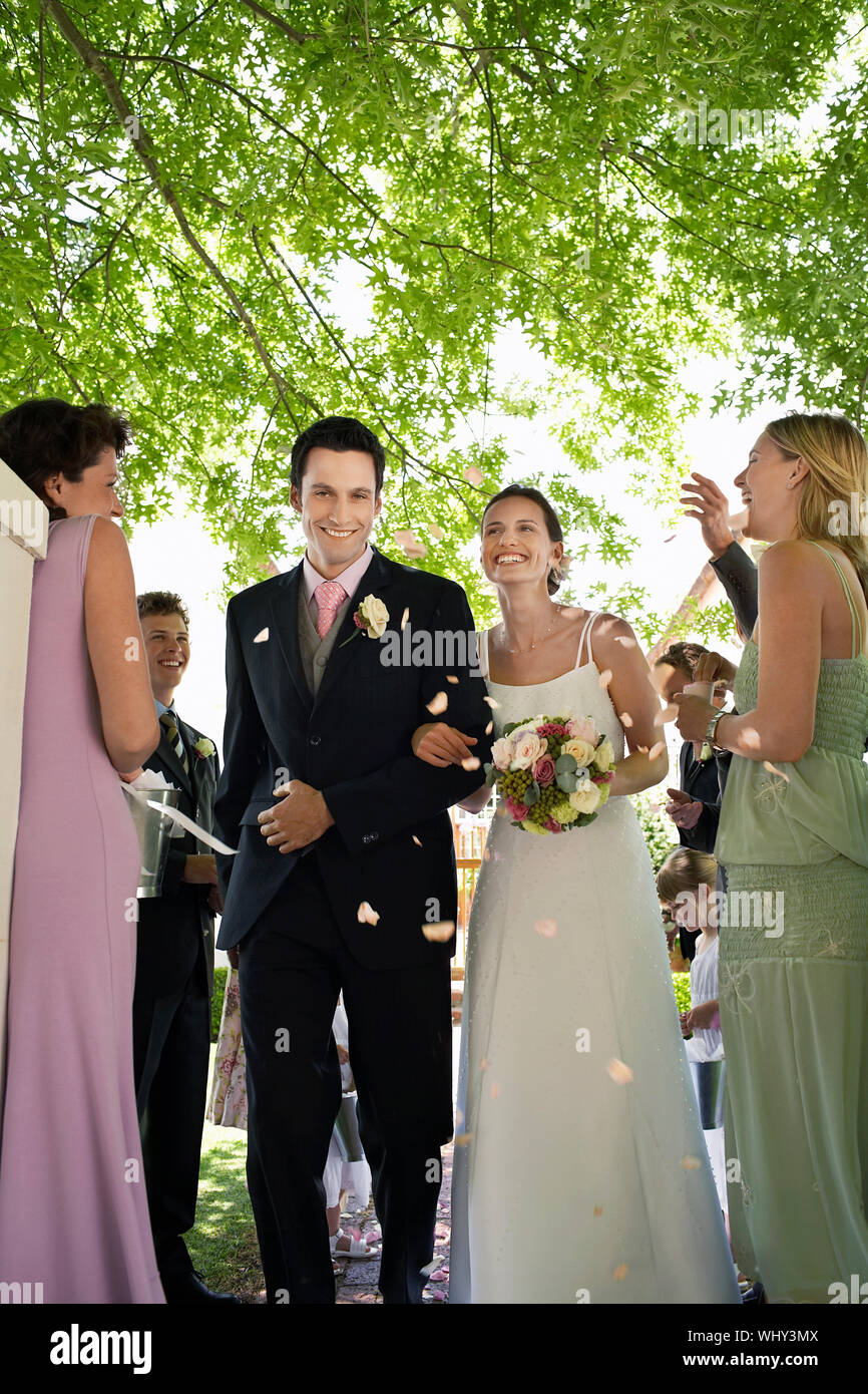 Guests throwing flower petals on bride and groom during wedding ceremony Stock Photo Alamy