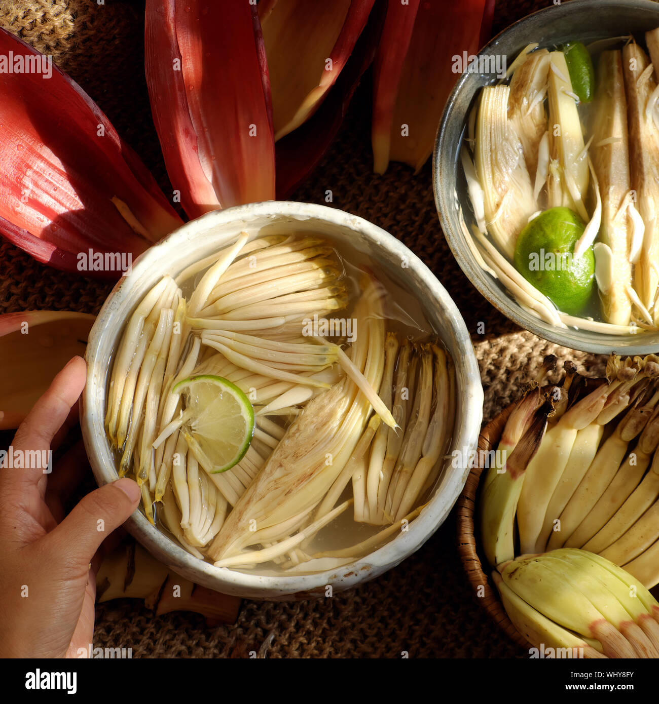 Top view prepare ingredients for vegan food from banana flower, woman hand  take young bananas, soaked in lemon water, blossom make many vegetarian  Stock Photo - Alamy
