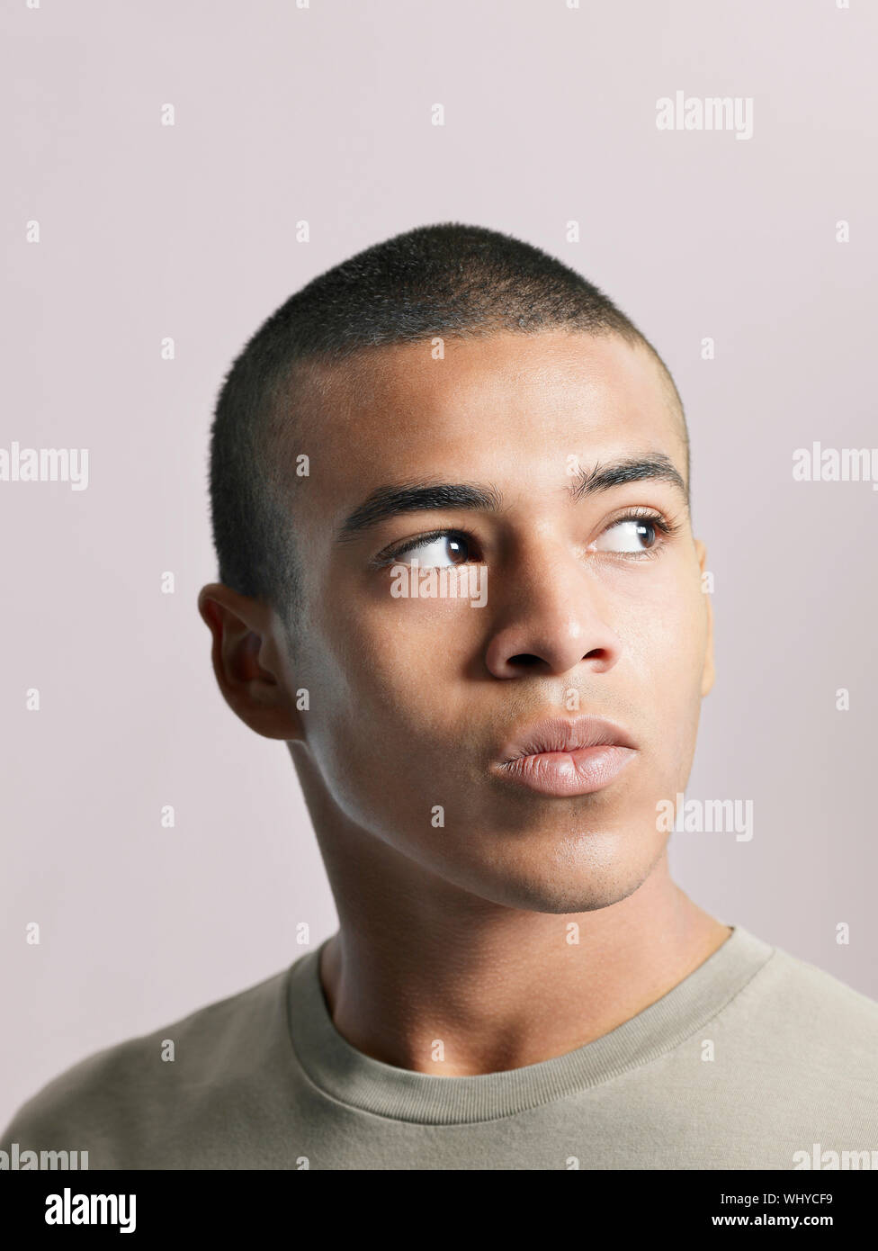 Closeup of young African American man looking away on colored background Stock Photo