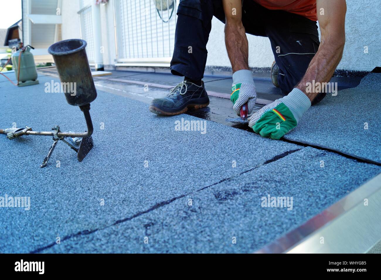 worker installing tar foil on the rooftop of building. Flat roof  installation. Waterproof system by gas and fire torching. Roofing felt  Stock Photo - Alamy
