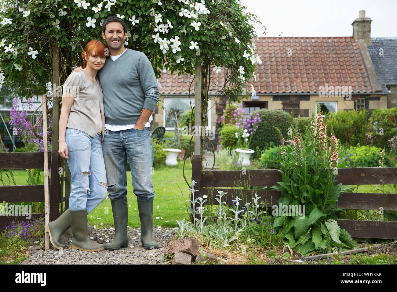Full length portrait of a couple standing outside country house Stock ...