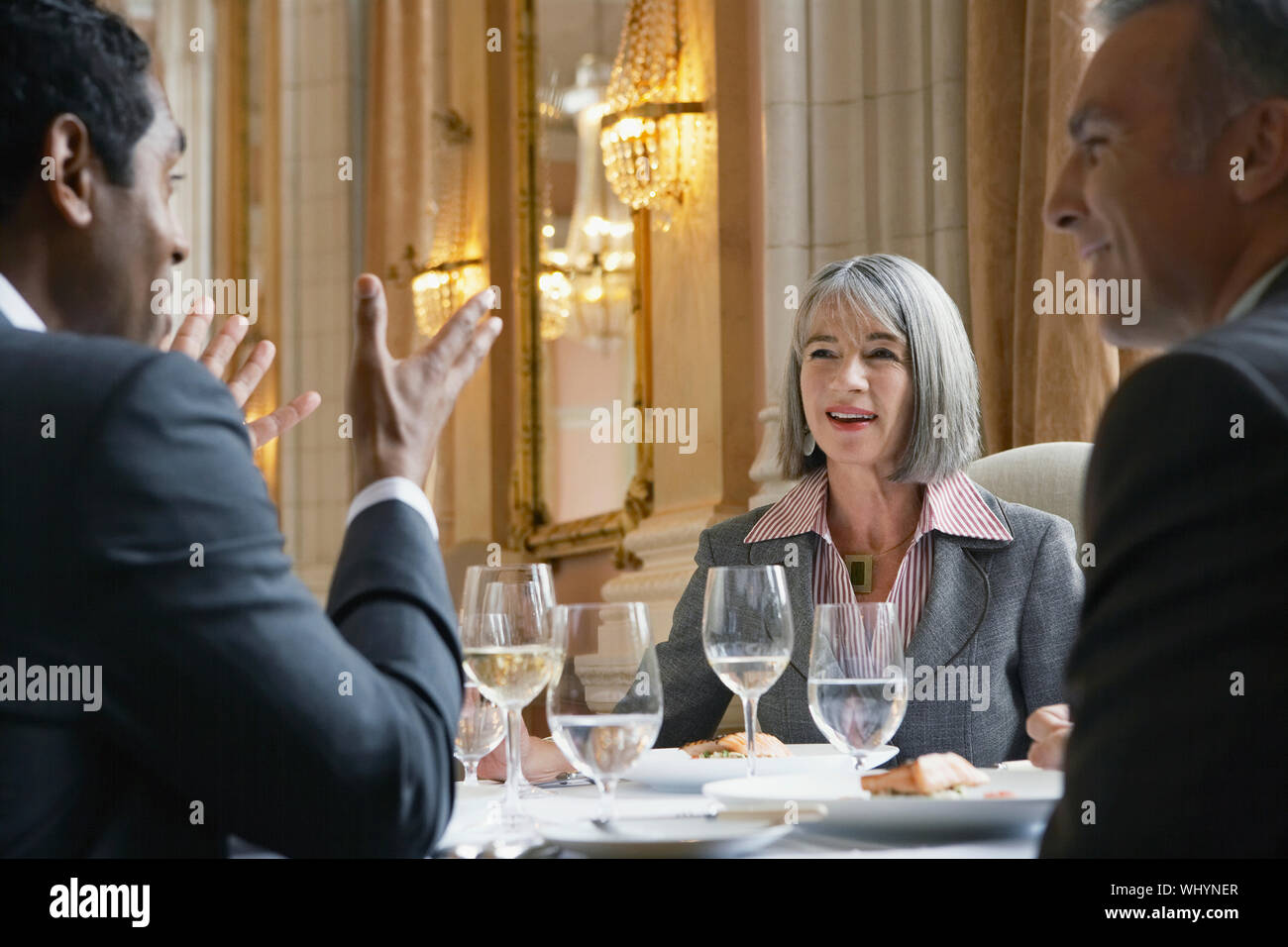 Multiethnic businesspeople sitting at restaurant table and talking Stock Photo