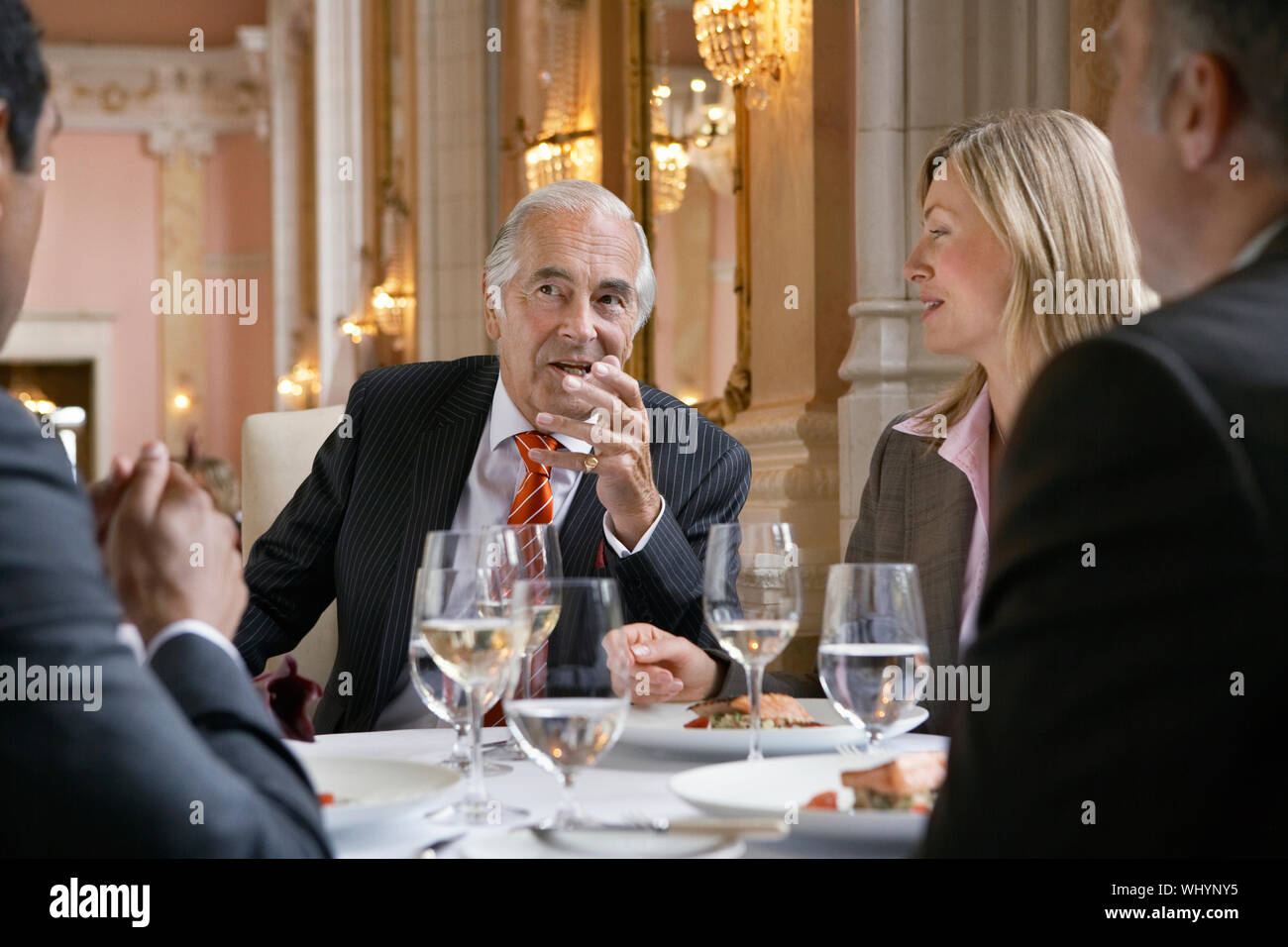 Multiethnic businesspeople sitting at restaurant table and talking Stock Photo