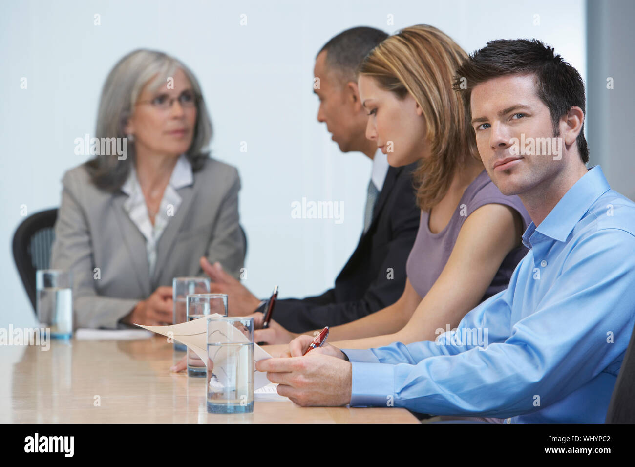 Group of multiethnic businesspeople sitting at conference table Stock Photo