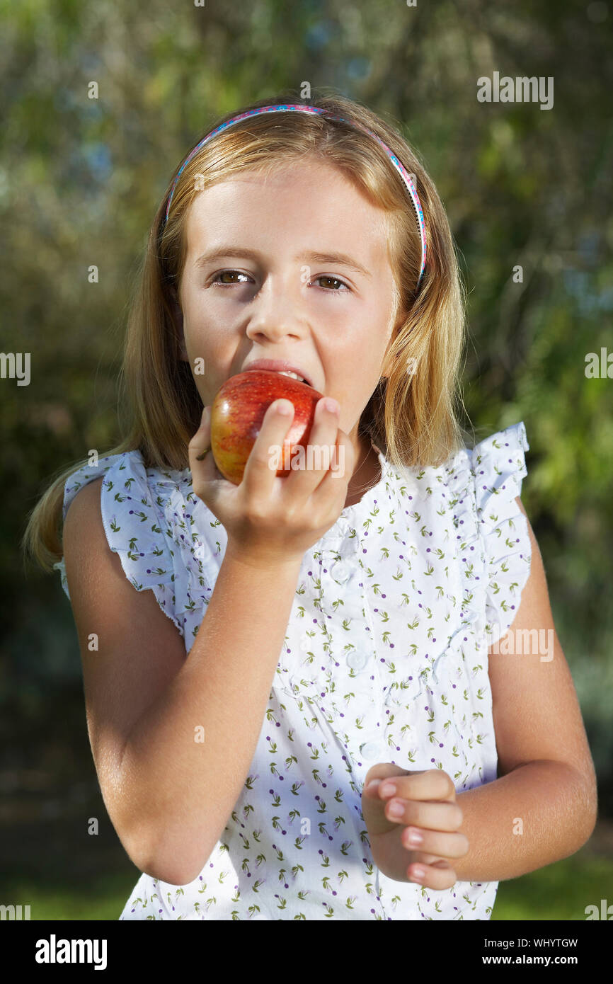 She s eating an apple. Девочка ест яблоко. Маленькая девочка ест яблоко. Маленькая девочка ест. Девушка ест яблоко.