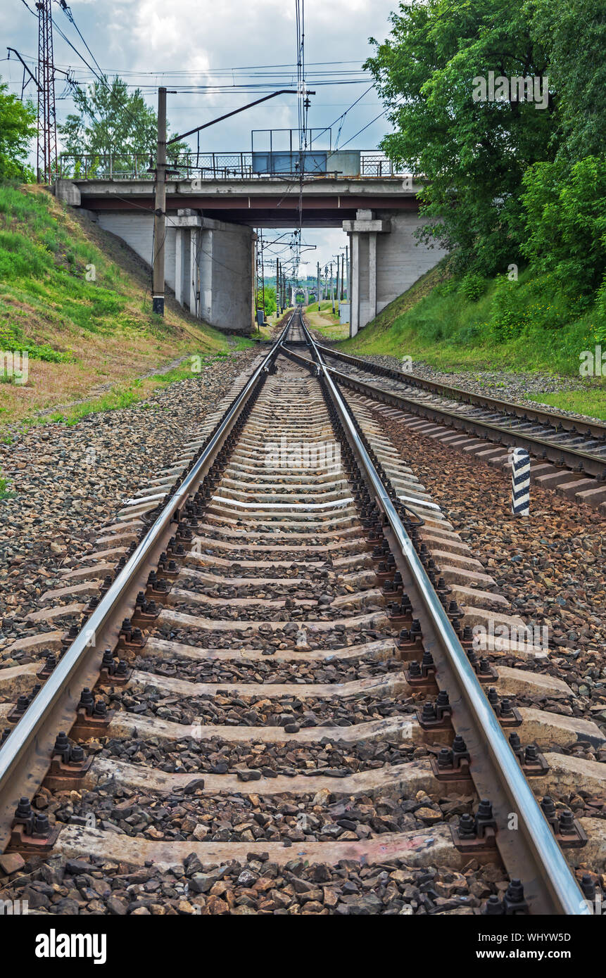 Electrified railway line crossing the road bridge and going to railway