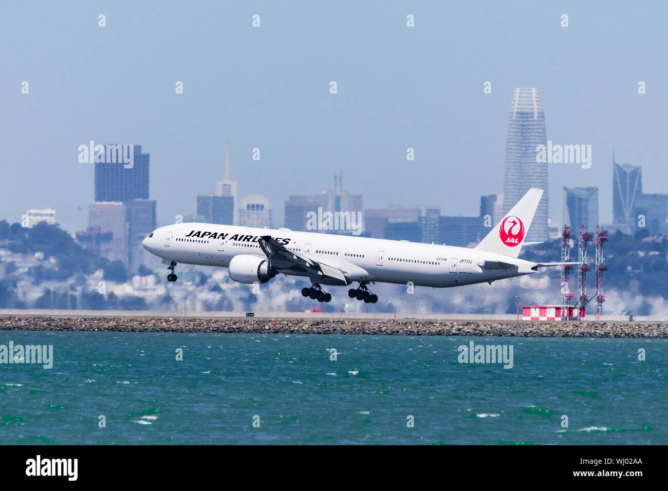September 1, 2019 Burlingame / CA / USA - Japan Airlines aircraft landing at San Francisco International Airport; Downtown San Francisco skyline visib Stock Photo