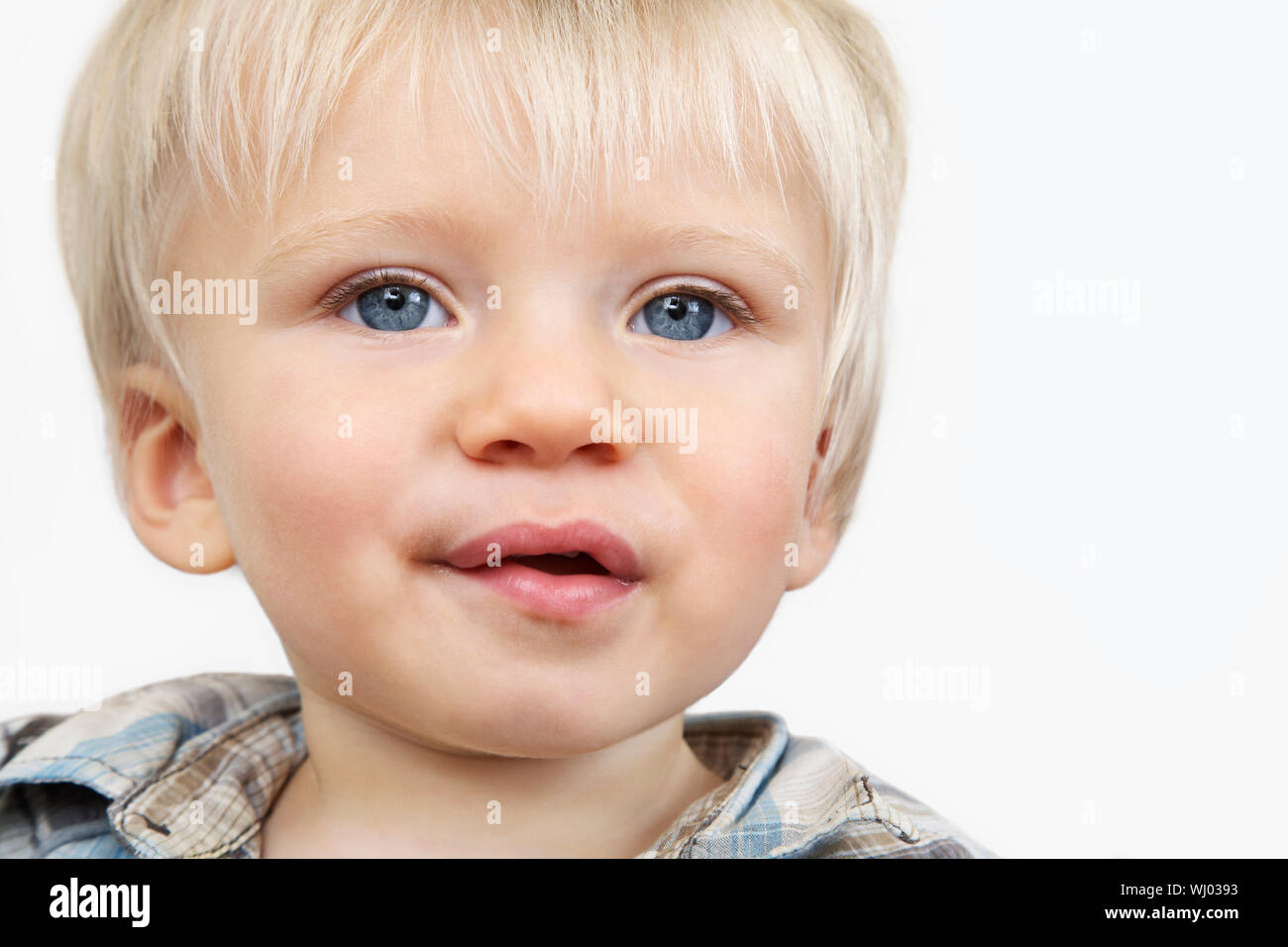 Closeup portrait of cute baby boy with blue eyes on white background ...