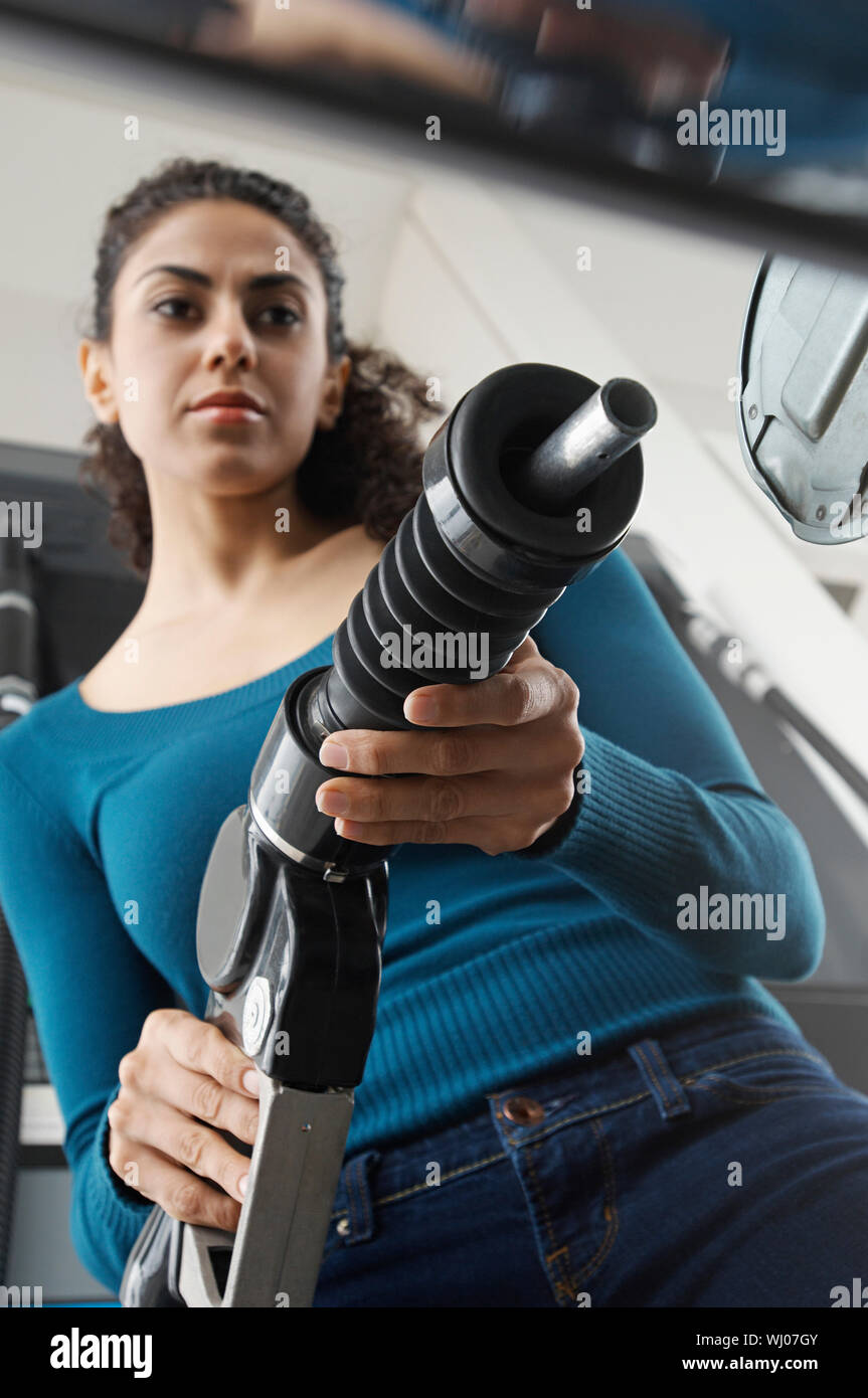 Woman holding fuel pump at gas station, tilt Stock Photo Alamy