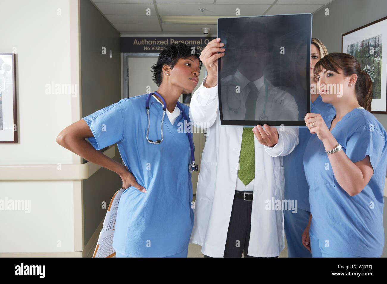 Group of doctors and nurses looking at X-ray in hospital Stock Photo