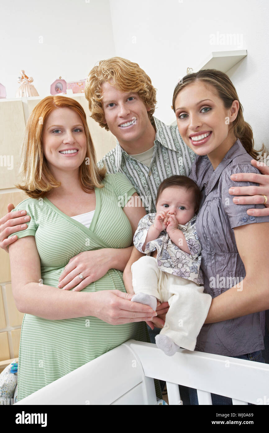 Portrait of two women, man and baby (1-6 months) in room Stock Photo ...