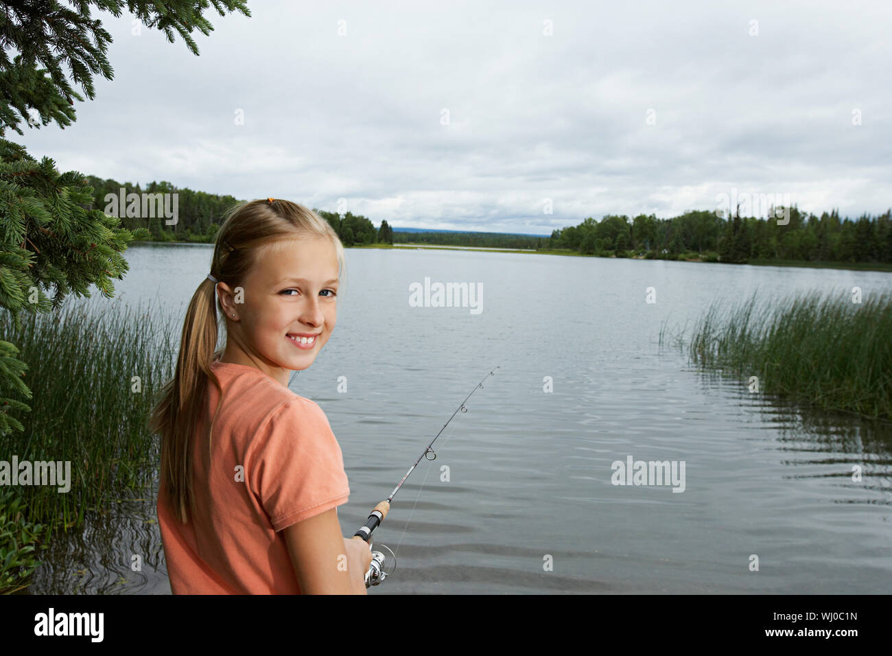 USA, Alaska, teenage girl fishing at lake, portrait Stock Photo