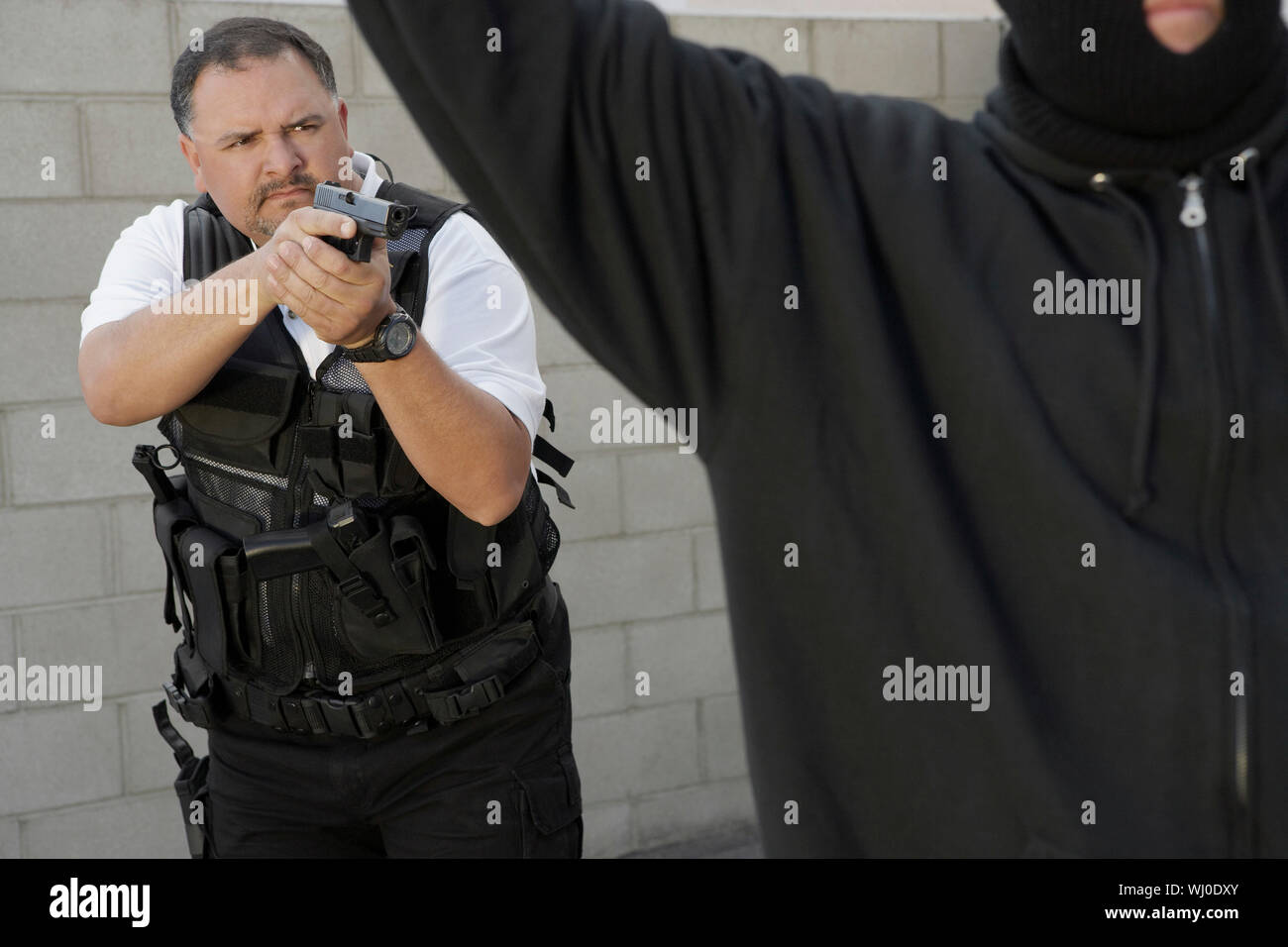 Security guard aiming gun at thief Stock Photo Alamy